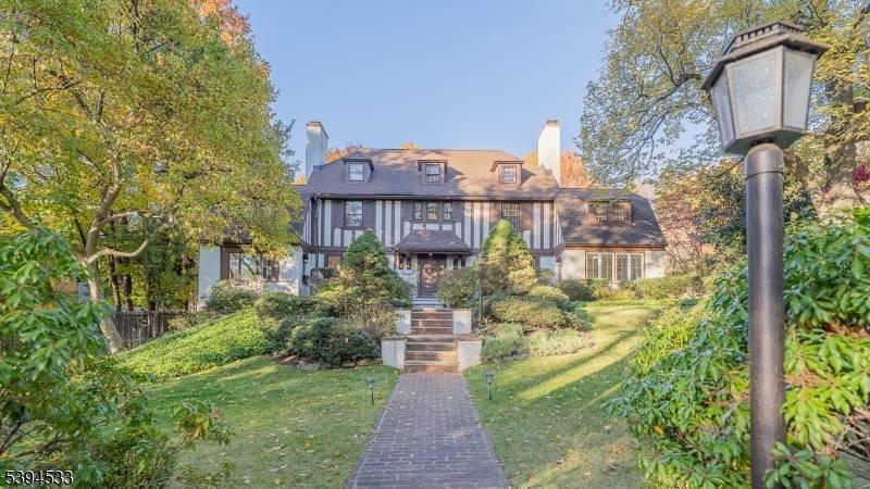 Built in 1911 masterfully updated for modern living, this distinguished English Tudor rests on over one acre of beautifully landscaped, private grounds in the heart of Old Short Hills.